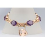 A 9ct yellow gold bracelet set with 7 oval cut amethysts each 12mm x 9mm and 6 seed pearls, having a