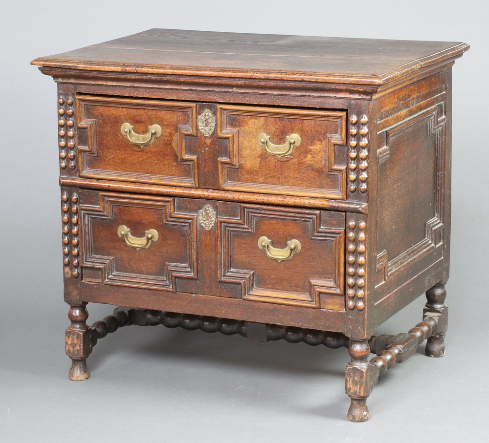 A Jacobean style oak chest of 2 drawers with geometric mouldings, replacement drop handles, raised