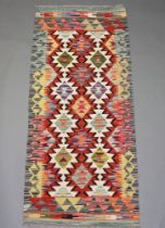 A white, orange and green ground Chobi Kilim runner with overall geometric design 154cm x 64cm