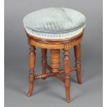 An Edwardian circular inlaid mahogany revolving piano stool on turned supports with X framed