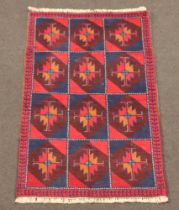 A red, blue and tan ground Belouche rug formed of 12 square medallions 136cm x 85cm