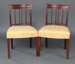 A pair of 19th Century mahogany stick and rail back dining chairs with over stuffed seats, raised on