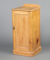 A Victorian pine pot cupboard with raised back, fitted a shelf enclosed by panelled door, on a