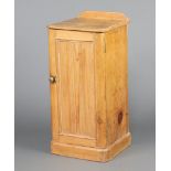 A Victorian pine pot cupboard with raised back, fitted a shelf enclosed by panelled door, on a