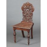 A Victorian oak hall chair, the carved and pierced solid back carved a green man, raised on turned