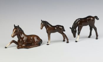 A Beswick figure of a foal lying No 915 brown gloss 8cm together with a ditto foal grazing No 946