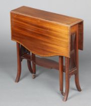 An Edwardian shaped and crossbanded mahogany Sutherland table with pierced splats to the sides