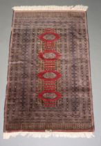 A brown, black and tan ground Bokhara rug with 4 stylised octagons to the centre within a multi