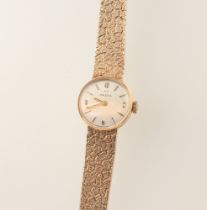 A lady's 9ct yellow gold Omega wristwatch contained in a 15mm case with a bark finished 9ct