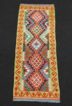 A yellow, green and orange ground Chobi Kilim runner 192cm x 62cm