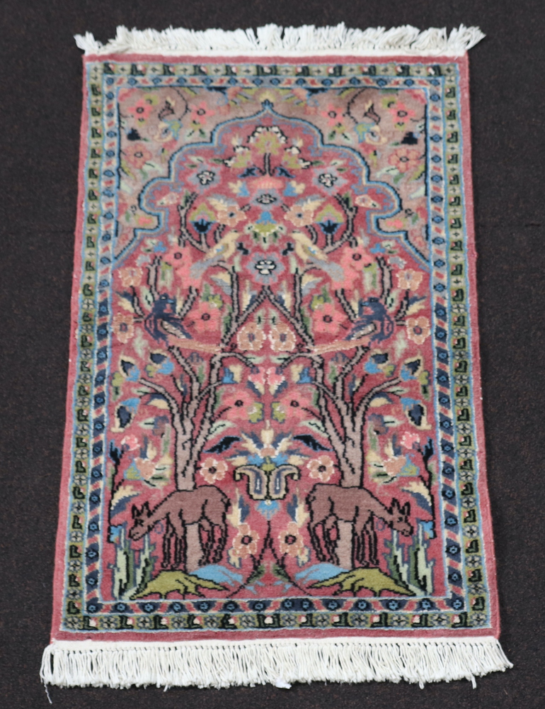 A pink ground and floral patterned Persian prayer rug 92cm x 58cm