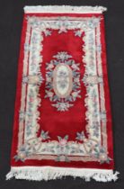 A red and white ground floral patterned Chinese rug 186cm x 89cm