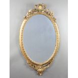 A 19th Century oval plate mirror contained in a decorative gilt frame surmounted by a shell 101cm