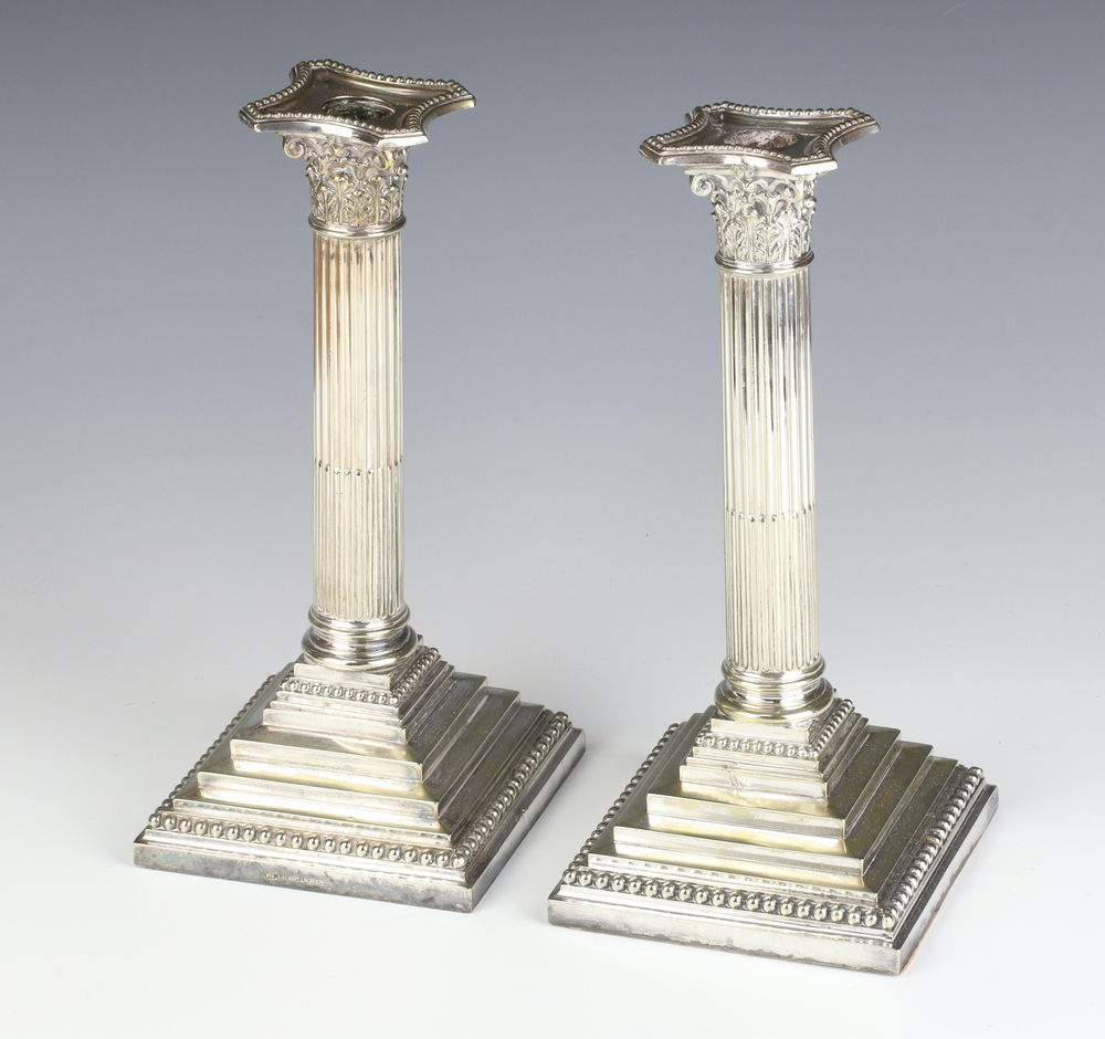 A pair of silver plated Corinthian column candlesticks 26cm