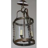 A circular wrought iron and glass hall lantern 41cm h x 21cm diam. This lot has not been tested