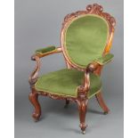 A Victorian carved mahogany show frame open armchair the seat and back upholstered in green material