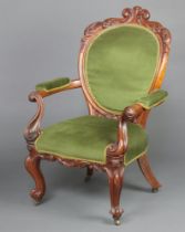 A Victorian carved mahogany show frame open armchair the seat and back upholstered in green material