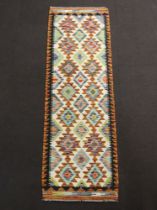 A yellow, white and black ground Chobi Kilim runner with diamond decoration to the centre 196cm x