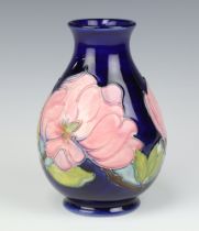 A Moorcroft blue glazed club shape vase decorated the Clematis pattern, base impressed Made in