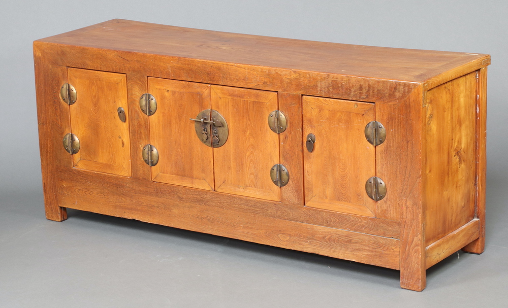 A Chinese light hardwood sideboard fitted cupboards enclosed by panelled doors with gilt metal