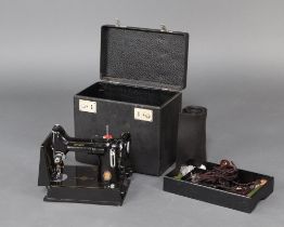 A 1951 Singer Featherweight electric sewing machine complete with foot control, bobbins, etc and