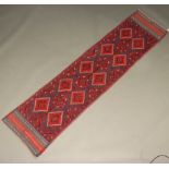 A red and black ground Meshwani runner with 14 diamonds to the centre 234cm x 57cm