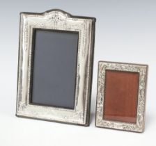 A modern embossed 925 standard easel photograph frame 11cm x 8cm, together with a silver