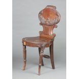 A Georgian mahogany carved hall chair with oval shaped back and seat, raised on turned and fluted