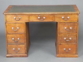 A Victorian oak desk with green leather writing surface above 1 long and 8 short drawers 82cm h x