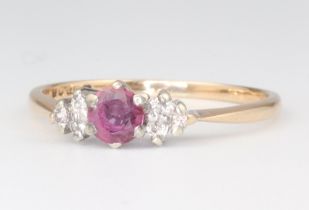 A 9ct yellow and white gold ruby and diamond set ring, the central ruby approx. 0.3ct, supported