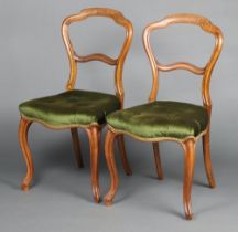 A pair of Victorian bleached mahogany balloon back dining chairs with shaped mid rails and