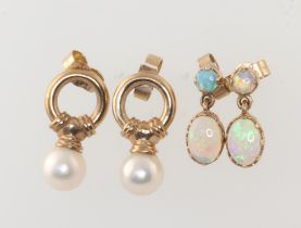 A pair of yellow metal opal set earrings together with a yellow metal pair of pearl drop earrings,