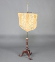 A Victorian gilt metal and carved walnut pole screen with shield shaped fabric banner, raised on a