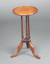 An Edwardian circular mahogany dish top wine table, raised on 3 turned columns with outswept