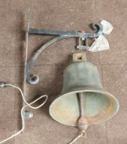 A large cast brass bell 29cm x 35cm, complete with iron bracket