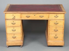 A Victorian light oak desk with red leather writing surface fitted 1 long and 8 short drawers 72cm h