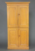 A Victorian pine scumble painted press cabinet with moulded cornice, both sections fitted shelves