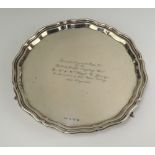 A silver salver with bracketed border raised on scroll supports Sheffield 1934, 26cm, with