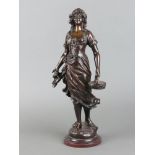 After Leon Perzinka, a bronze figure of a standing lady with basket of fish, raised on a marble base
