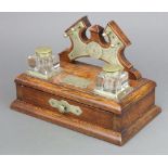 An Edwardian oak and silver plated standish the raised back with pen rack and 2 square cut glass