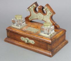 An Edwardian oak and silver plated standish the raised back with pen rack and 2 square cut glass