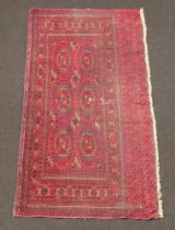 A section of blue and red ground Bokhara rug 176cm x 87cm In wear