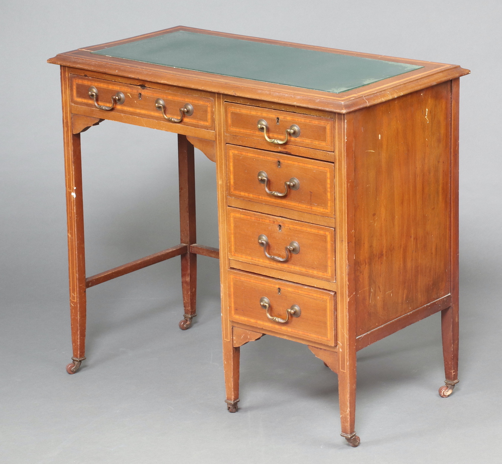 An Edwardian inlaid and crossbanded mahogany desk with inset glass panel fitted 1 long and 4 short