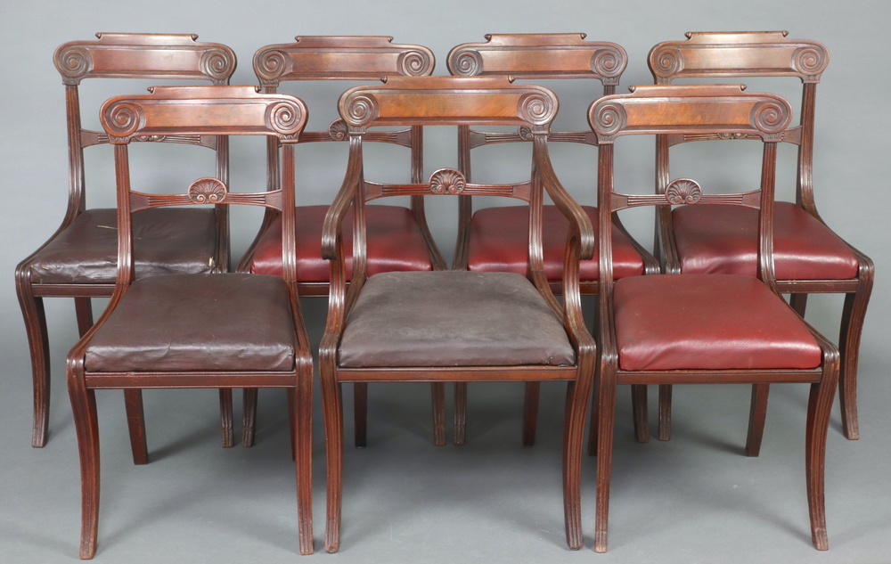 A set of 7 Regency bar back dining chairs with carved mid rails and upholstered drop in seats,