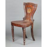 A 19th Century mahogany hall chair, the shaped solid back with armorial, solid seat, raised on