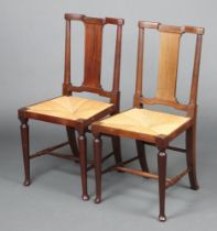 A pair of Edwardian Arts and Crafts mahogany slat back bedroom chairs with woven rush seats raised