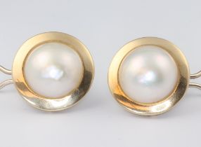 A pair of yellow metal marked 750 and large Mabe pearl earrings, the pearls set in a flat circular