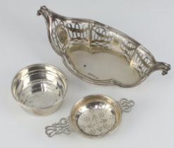 An Edwardian pierced boat shaped twin handled dish London 1909, silver tea strainer and stand