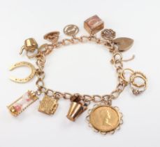 A 9ct gold curb link charm bracelet hung a Elizabeth II 1965 sovereign and 12 other charms, gross