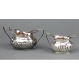 A Victorian silver twin handled sugar bowl with demi-reeded decoration together with a matching